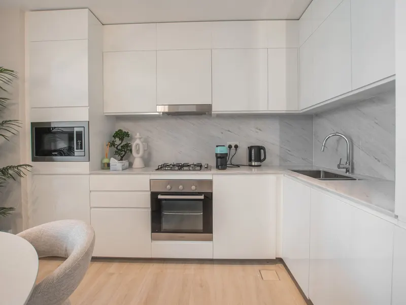 A person carefully cleaning a kitchen cabinet